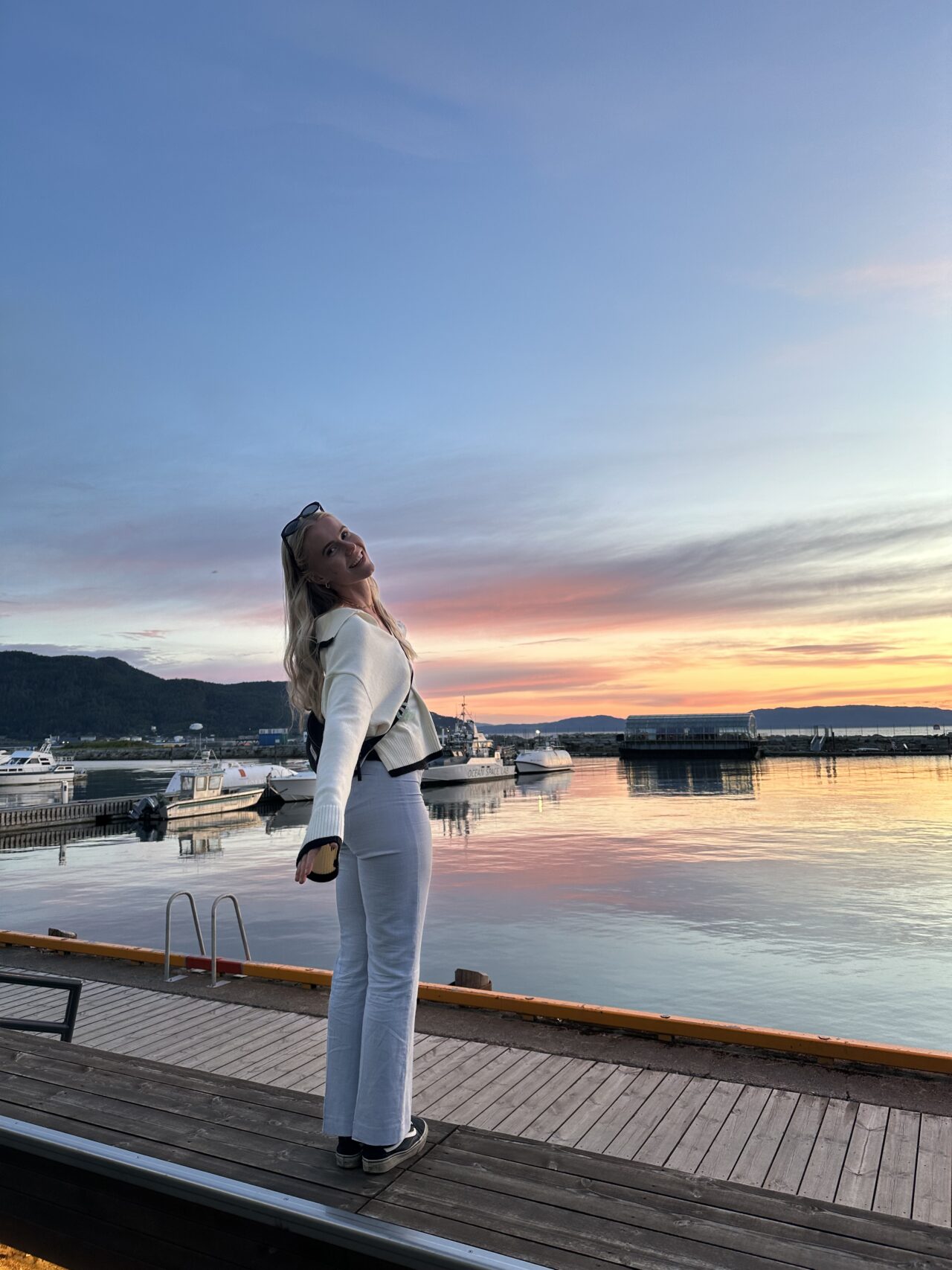 Person som står på en brygge med fin himmel i bakgrunnen